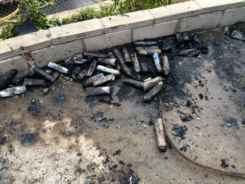 Multiple butane canisters on the ground.