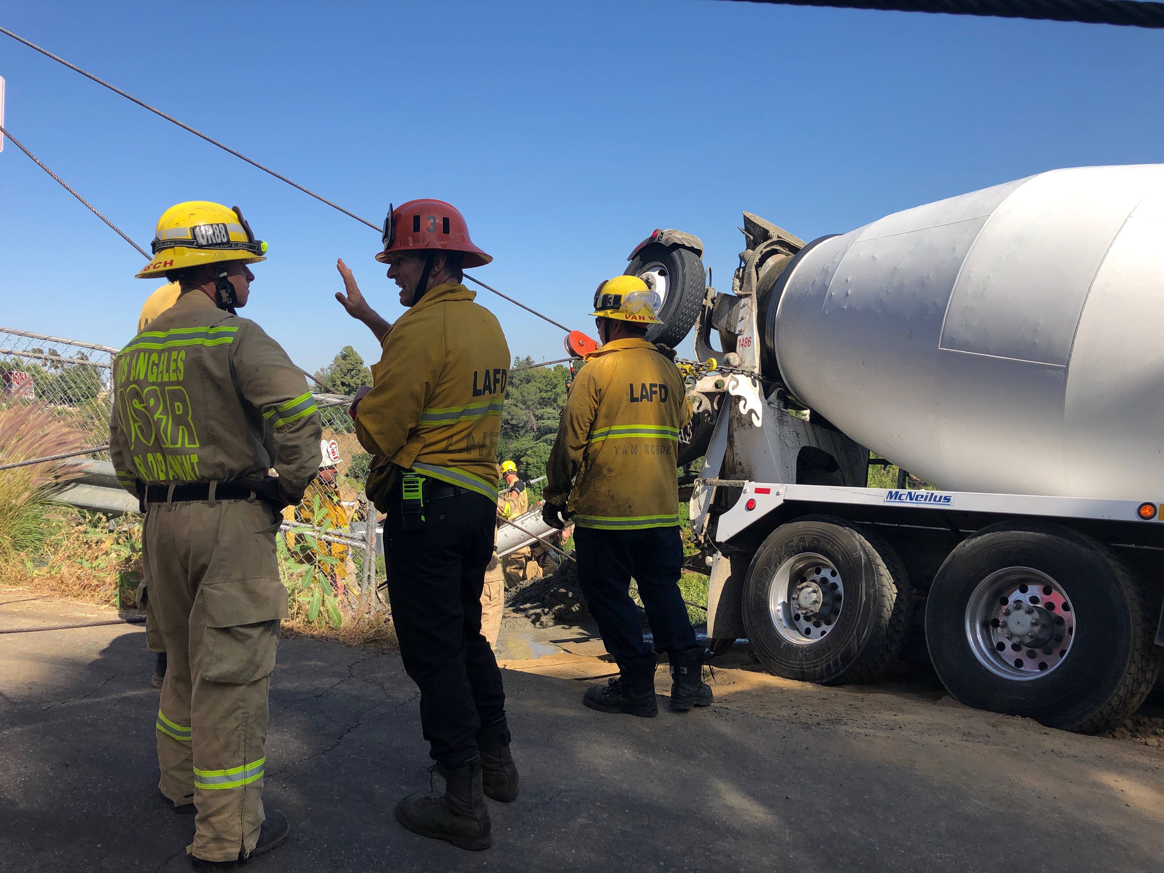 Rigging shown leading to the mixer truck with firefighters in the foreground